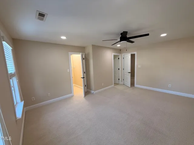 a view of an empty room with a ceiling fan
