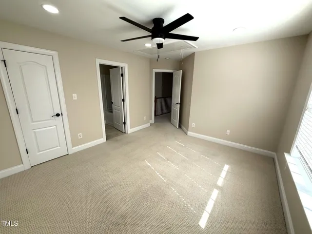 an empty room with a window and a ceiling fan