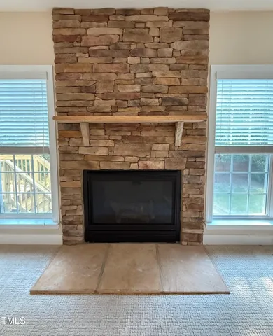 a living room with a fireplace in front of a window