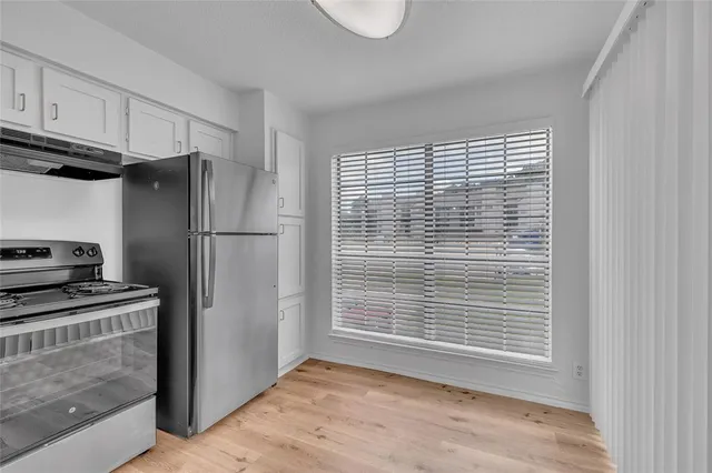 a kitchen with granite countertop a stove sink and cabinets