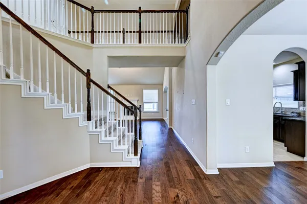 a view of staircase with wooden floor and a chandelier