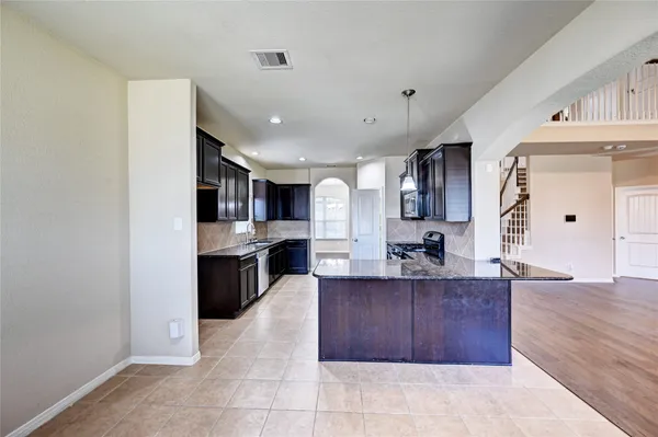 a large kitchen with a large counter top stainless steel appliances and cabinets