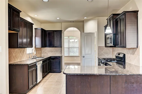 a kitchen with stainless steel appliances granite countertop a sink and a stove