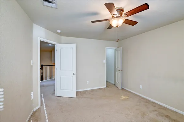 an empty room with a ceiling fan and a window