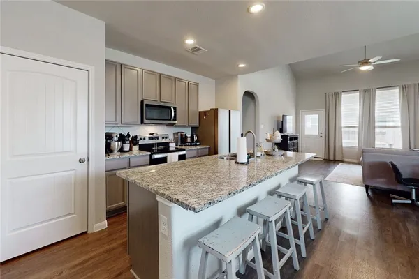 a kitchen with stainless steel appliances granite countertop a stove refrigerator and a sink