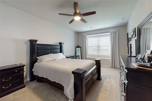 a bedroom with a bed dresser and a window