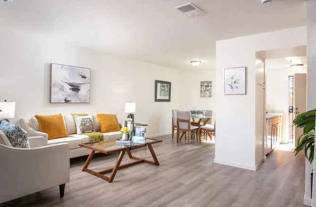 a living room with furniture and wooden floor