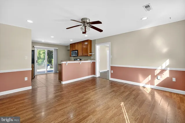 a view of a livingroom with a kitchen counter top and wooden floor