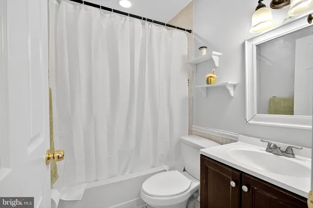 a bathroom with a sink a toilet and shower curtain