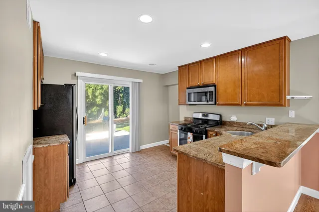 a kitchen with stainless steel appliances granite countertop a refrigerator a stove top oven a sink and dishwasher