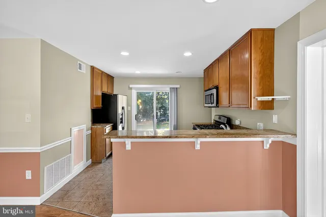 a kitchen with stainless steel appliances granite countertop a sink a stove and a refrigerator