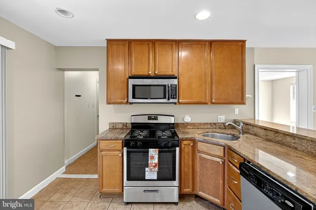 a kitchen with granite countertop cabinets stainless steel appliances and a counter space