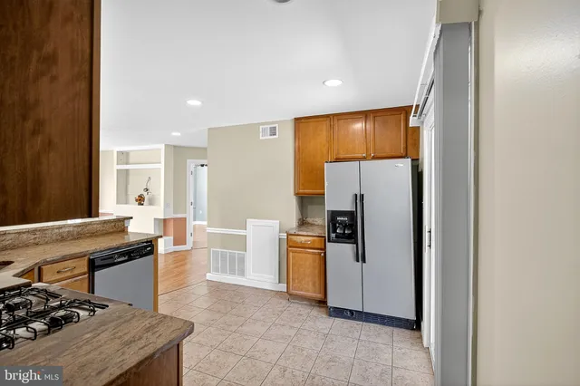 a kitchen with stainless steel appliances granite countertop a refrigerator and a stove top oven