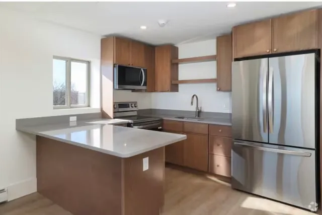 a kitchen with stainless steel appliances granite countertop a refrigerator a sink a stove a microwave and island