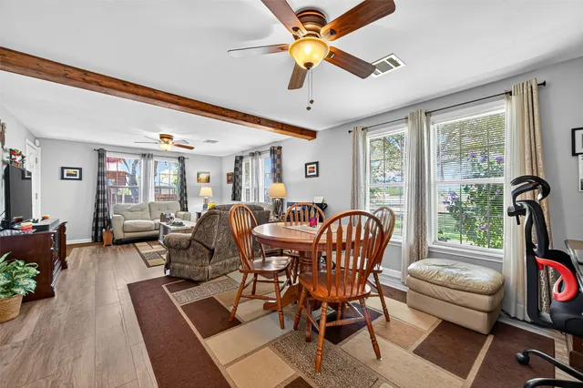 a dining room with furniture a flat screen tv and a large window