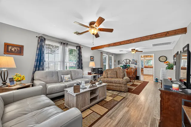 a living room with furniture ceiling fan and a window