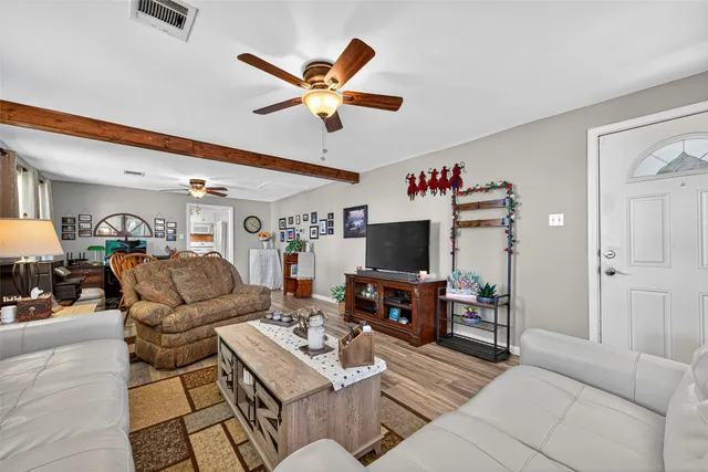 a living room with furniture kitchen view and a flat screen tv