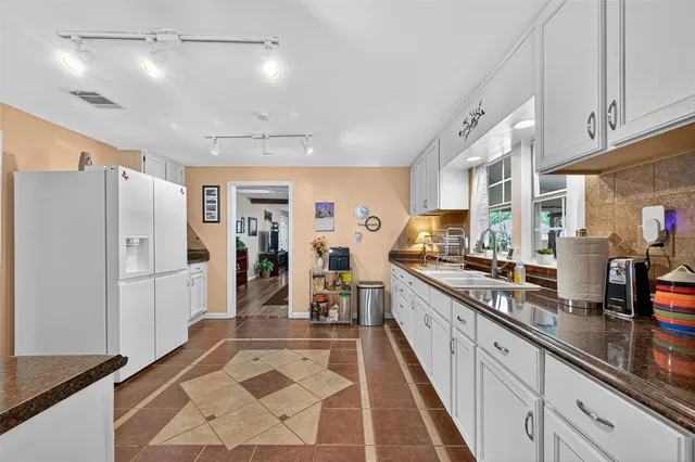 a kitchen with stainless steel appliances granite countertop a refrigerator and a sink