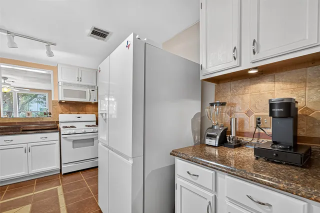 a kitchen with appliances a sink and cabinets