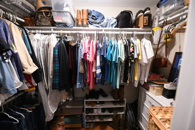 a view of walk in closet with clothes and shoes