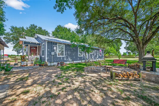 a view of a house with backyard and sitting area