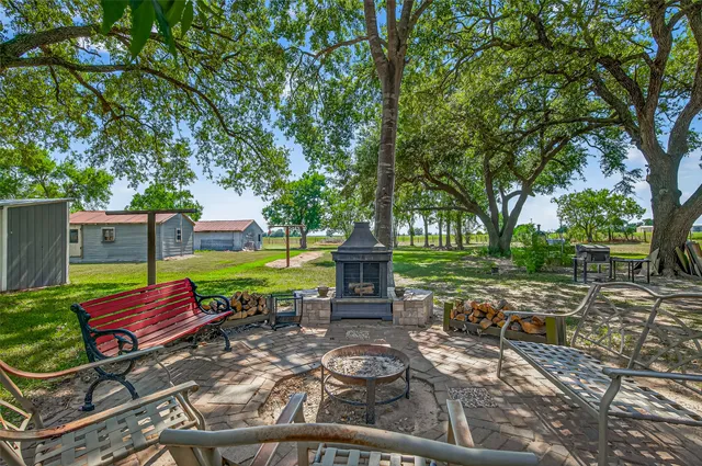 a view of a patio with table and chairs next to a yard