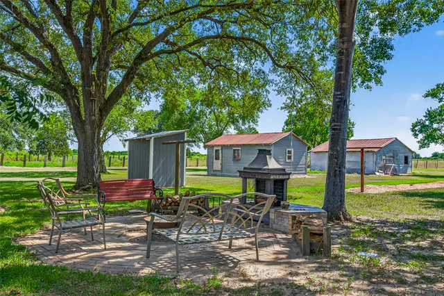 a view of a house with a yard patio and a fire pit