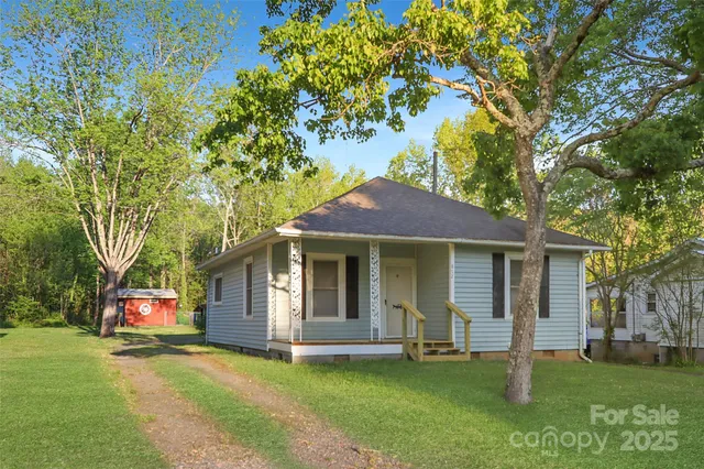 a front view of a house with a garden and tree
