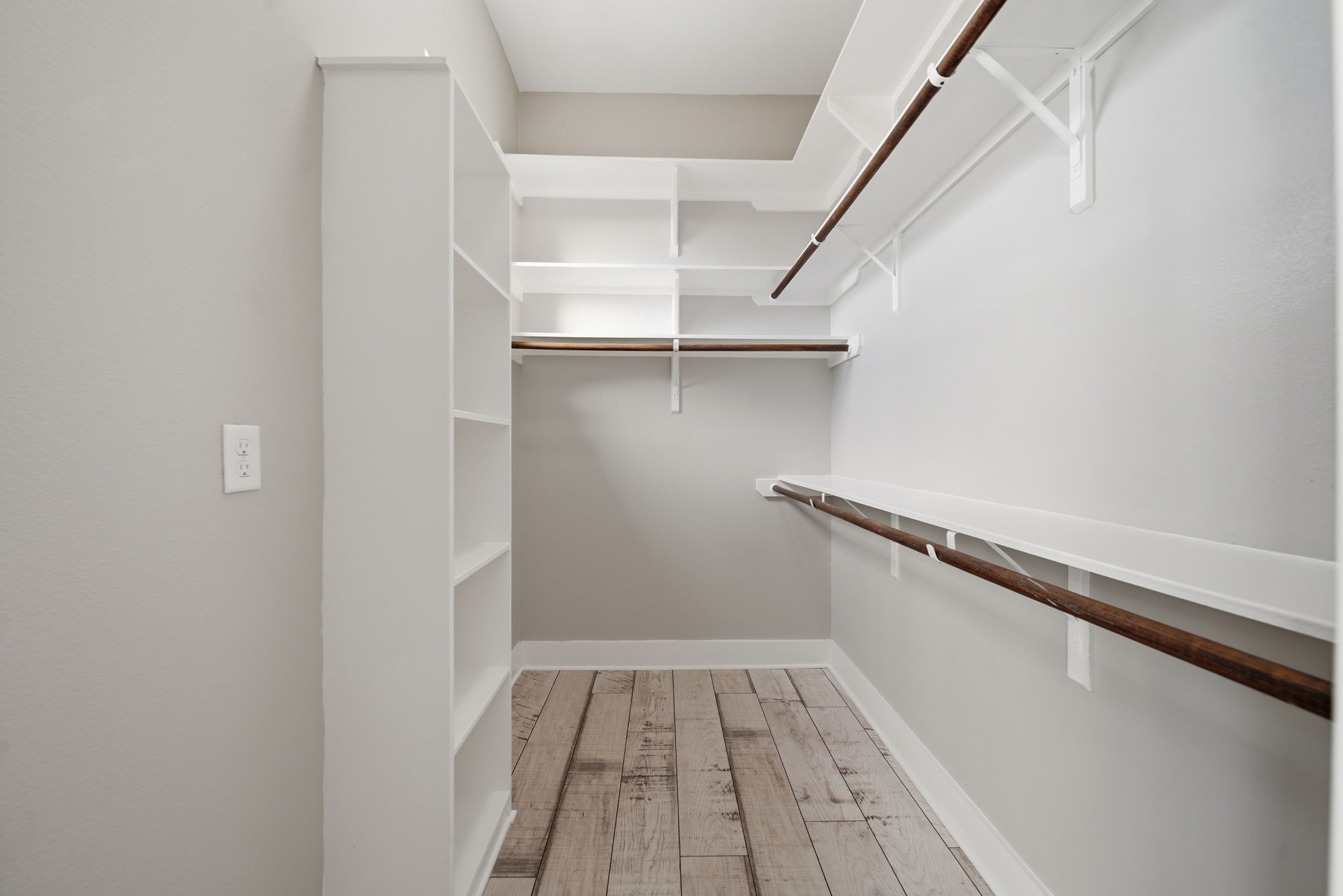 1814 Thompson Street Houston, TX 77007 - Photo 14 of 37 One of two spacious walk-in closets designed for elevated storage and organization. Featuring light gray walls, warm wood flooring, and extensive shelving and hanging space, this bright, well-lit closet blends functionality with modern style.