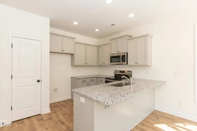 a view of a kitchen with a sink stainless steel appliances and cabinets