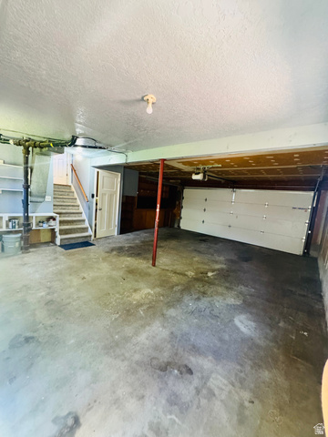 4245 3320 East Holladay, UT 84124 - Photo 44 of 51 Spacious garage with a concrete floor, overhead lighting, and a white paneled garage door