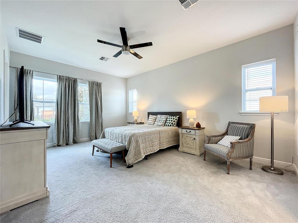 9062 Sperry Street Orlando, FL 32827 - Photo 18 of 44 a spacious bedroom with a bed and a chandelier