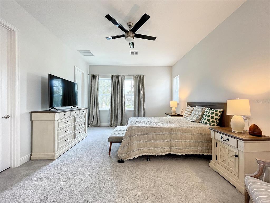 9062 Sperry Street Orlando, FL 32827 - Photo 19 of 44 a bedroom with a bed and a flat screen tv