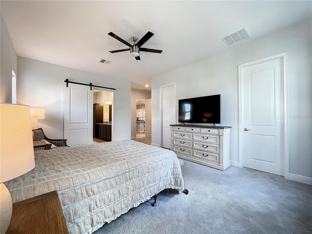 9062 Sperry Street Orlando, FL 32827 - Photo 20 of 44 a spacious bedroom with a bed and a flat screen tv