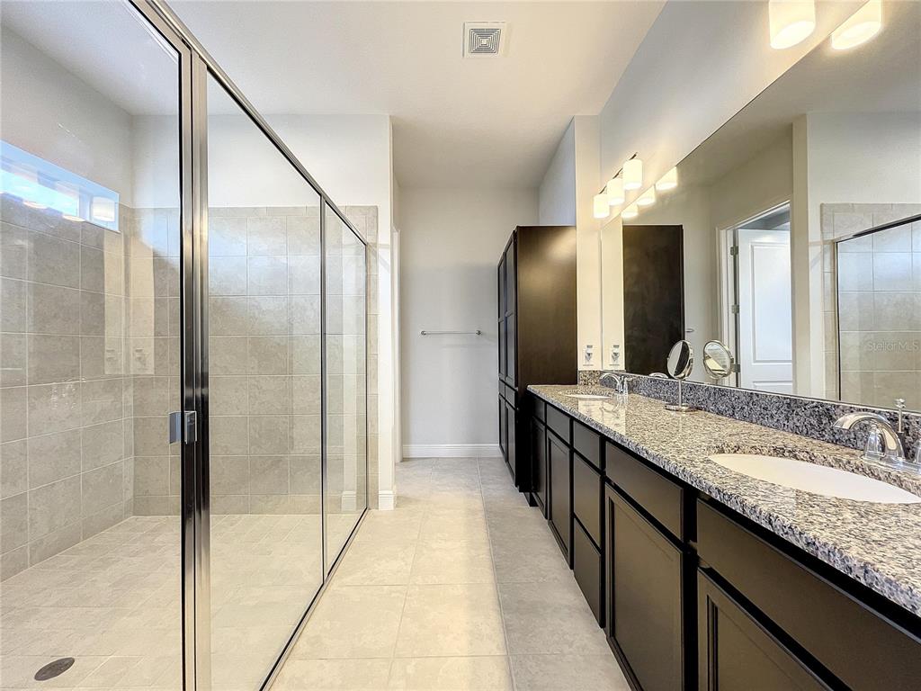 9062 Sperry Street Orlando, FL 32827 - Photo 21 of 44 a bathroom with a granite countertop double vanity and a mirror