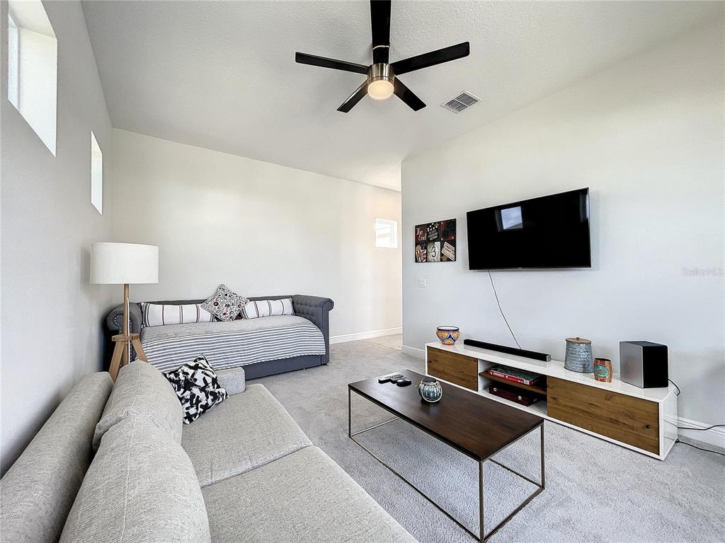 9062 Sperry Street Orlando, FL 32827 - Photo 27 of 44 a living room with furniture and a flat screen tv