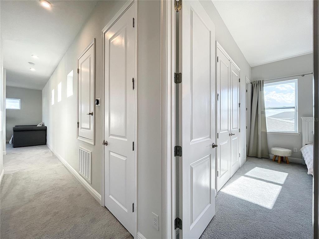 9062 Sperry Street Orlando, FL 32827 - Photo 28 of 44 a view of a hallway with a livingroom and a bathroom with mirror