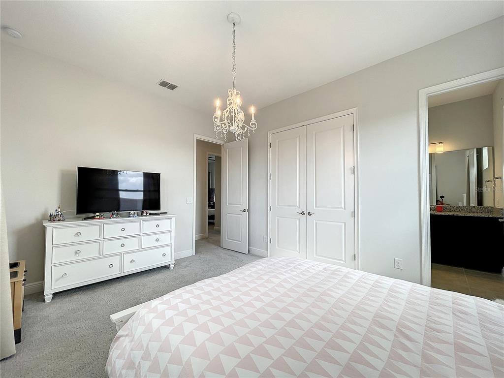 9062 Sperry Street Orlando, FL 32827 - Photo 29 of 44 a bedroom with a bed and a flat screen tv