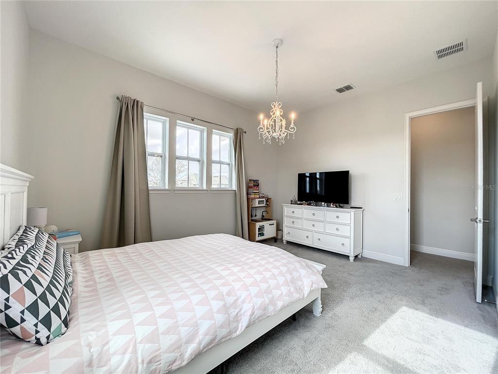 9062 Sperry Street Orlando, FL 32827 - Photo 35 of 44 a bedroom with a bed and a chandelier