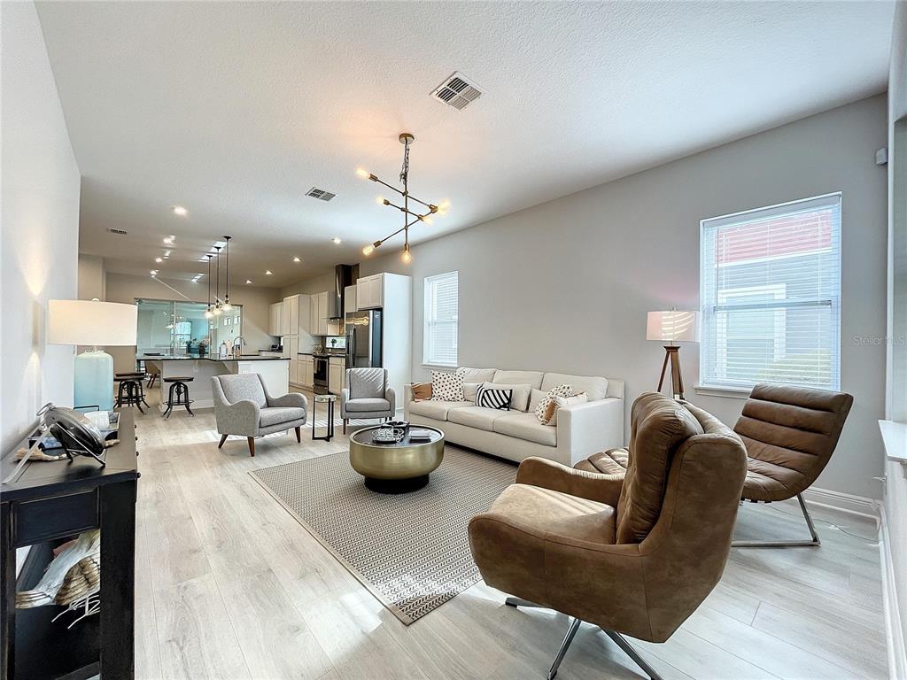 9062 Sperry Street Orlando, FL 32827 - Photo 5 of 44 a living room with furniture and a chandelier