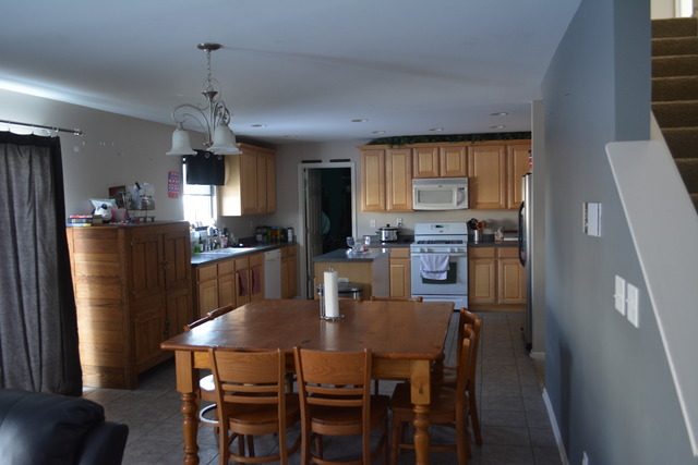 718 Wilson Street Waterman, IL 60556 - Photo 4 of 7 a kitchen with stainless steel appliances granite countertop a dining table chairs refrigerator and microwave