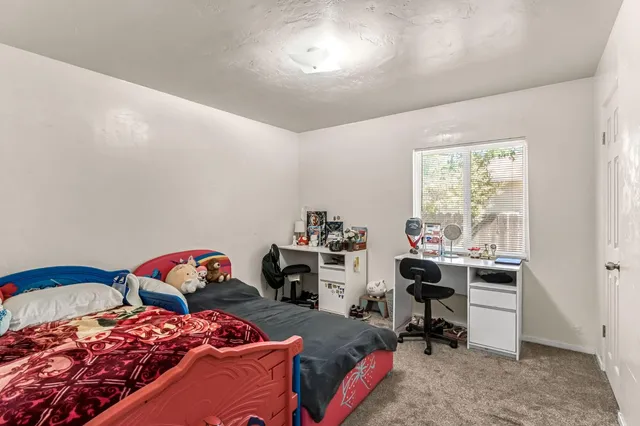a bedroom with two beds and a desk
