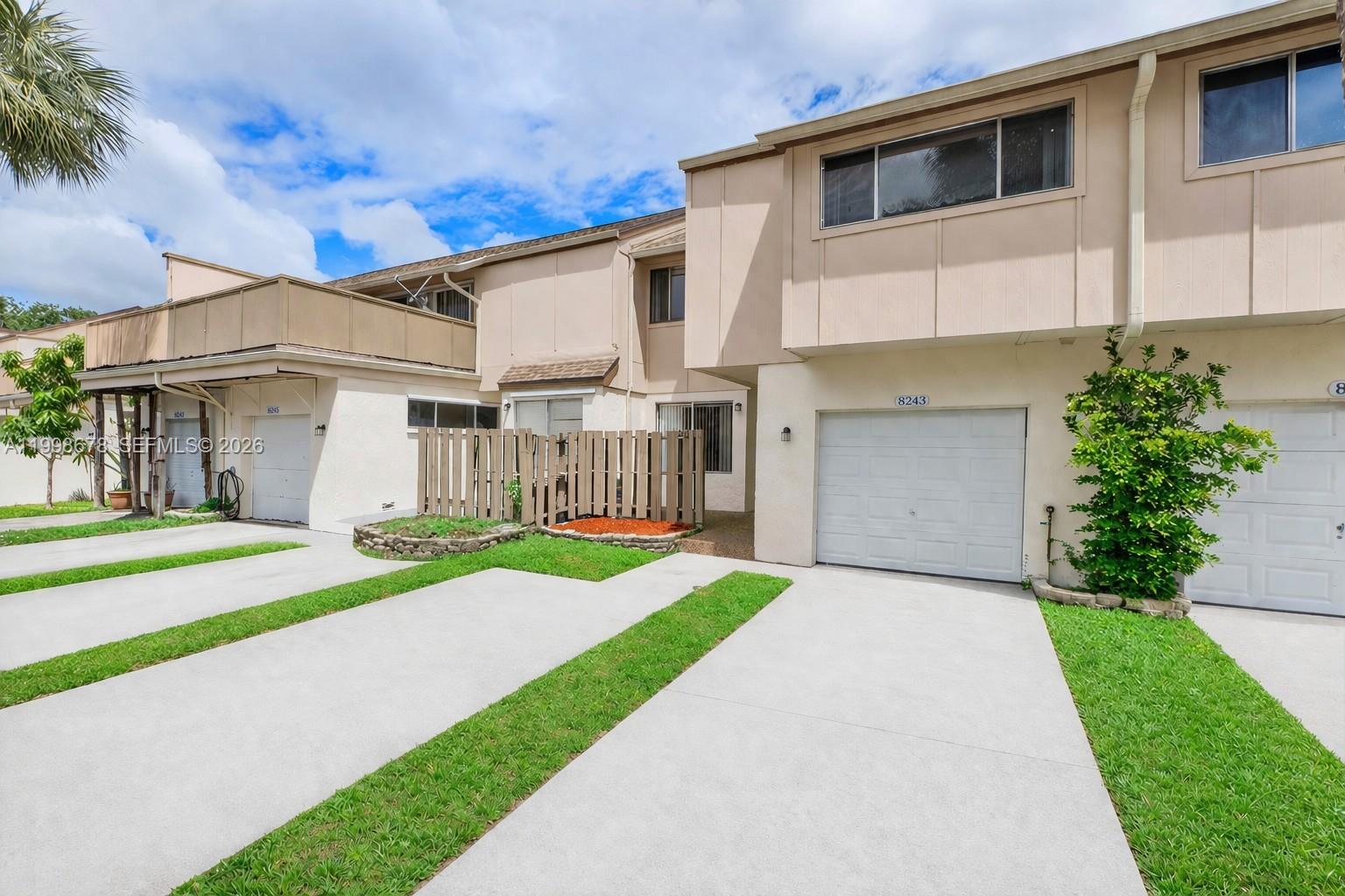 8243 Northwest 9th Street, Unit 7 Plantation, FL 33324 - Photo 1 of 30 a front view of a house with a yard and garage
