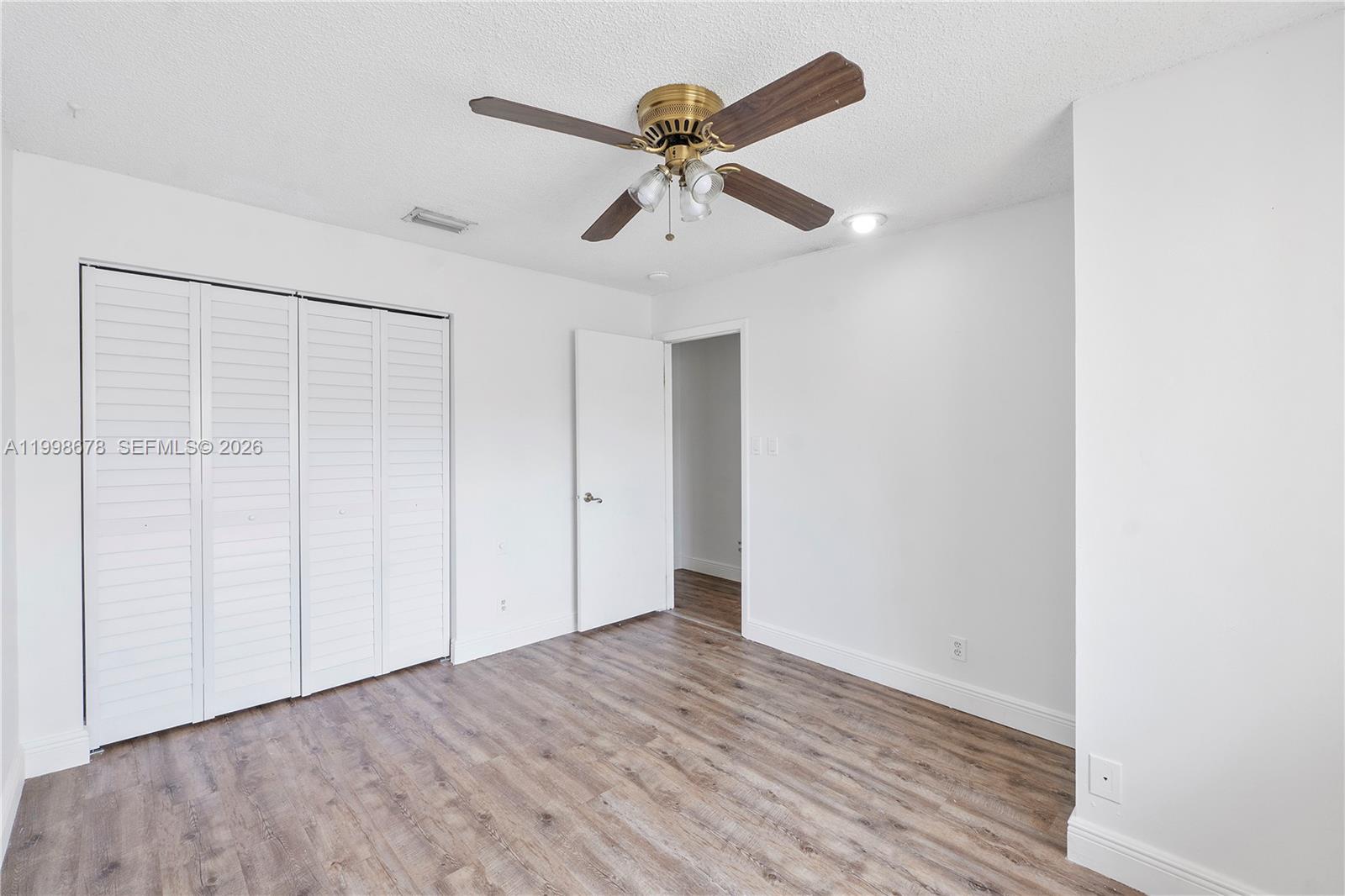 8243 Northwest 9th Street, Unit 7 Plantation, FL 33324 - Photo 13 of 30 an empty room with a ceiling fan and wooden floor