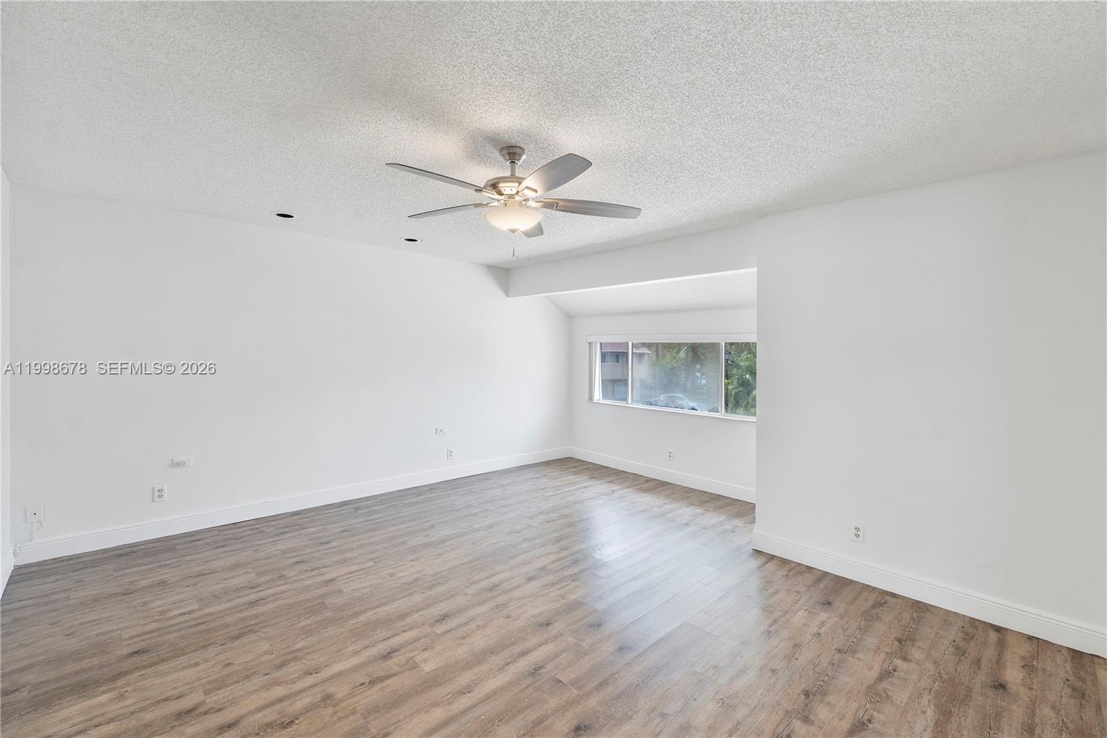 8243 Northwest 9th Street, Unit 7 Plantation, FL 33324 - Photo 16 of 30 a view of an empty room with a window and wooden floor