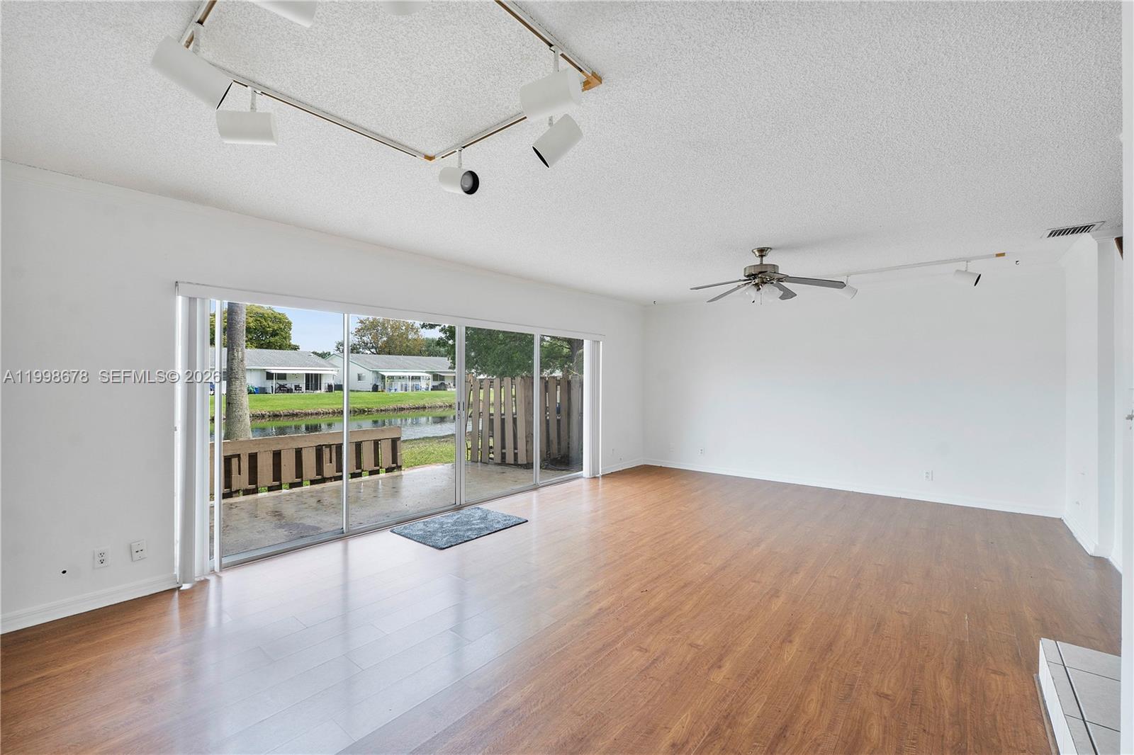 8243 Northwest 9th Street, Unit 7 Plantation, FL 33324 - Photo 3 of 30 a view of an empty room with a window and wooden floor