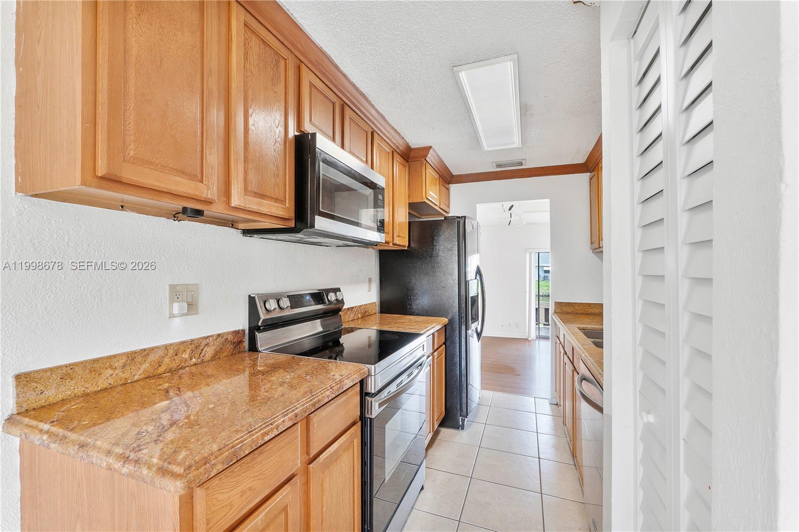 8243 Northwest 9th Street, Unit 7 Plantation, FL 33324 - Photo 8 of 30 a kitchen with stainless steel appliances granite countertop a sink and a refrigerator