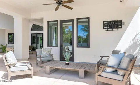 a view of a chairs and table in patio next to a yard
