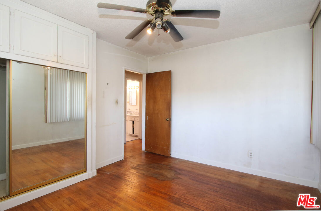 1022 West 156th Street Compton, CA 90220 - Photo 15 of 24 a view of an empty room with window and wooden floor