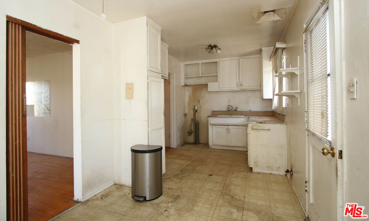 1022 West 156th Street Compton, CA 90220 - Photo 16 of 24 a kitchen with white cabinets and refrigerator